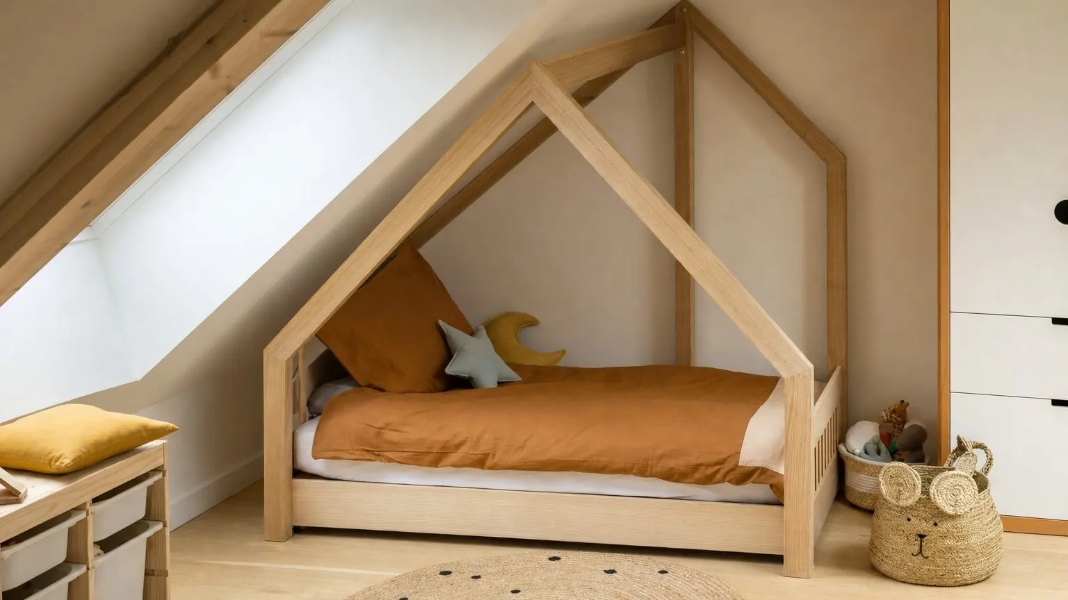 Lit cabane installé sous une pente de toit, dans une chambre mansardée, avec une hauteur dégagée au-dessus du matelas