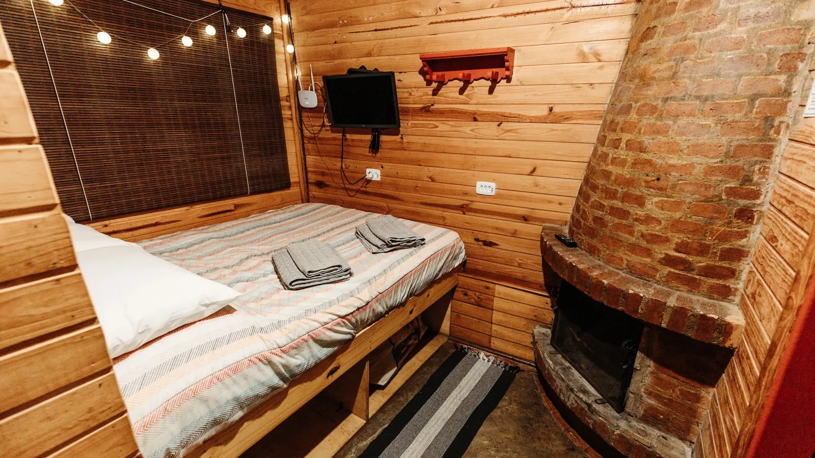 Lit cabane avec toboggan en bois dans une chambre d'enfant, couchage surélevé et barrière de sécurité
